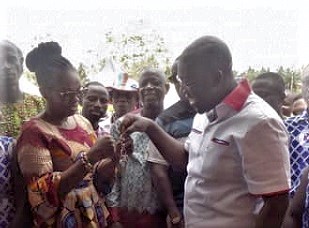 Kojo Oppong Nkrumah (right) presenting the keys to the building to Akua Ayisi, the Akyemansa District Director of Education.